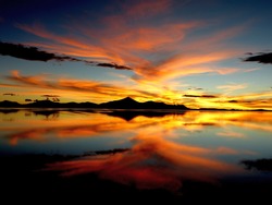 Orange sunset over salt lake in desert Scenic sky clouds reflection in water, Impressive golden nightfall, Spectacular night landscape, Colored heaven Salt flats Uyuni, Altiplano, Gold bright sundown
