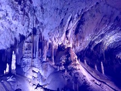 Magic underground cave formations. Postojna Cave fascinating subterranean paradise. Cave boasts towering mountains, murmuring vast subterranean halls. Speleobiology dream. Awe stalagmites, stalactites