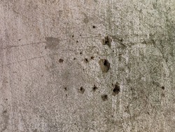 Perfect background shot for designers of a beautiful unique grey wall with real bullet shot holes