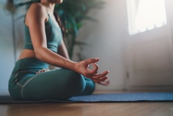 Morning Mindfulness Meditation, Closeup of young woman practicing yoga in the morning sitting straight and comfortable on yoga mat, blank space for text or content