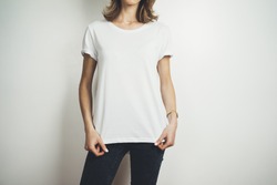 Cropped image of young hipster girl wearing blank white t-shirt and black jeans, mock-up of blank white t-shirt, white background