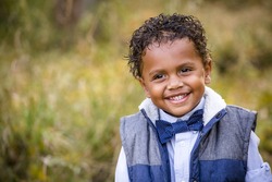 Cute outdoor portrait of a smiling African American young boy