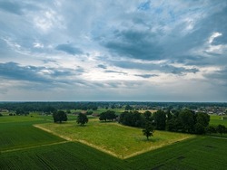 Aerial view of dramatic storm clouds over farm fields. Country landscape of the bad weather. Very windy weather. Plain field against the background of dark sky and clouds forming. High quality photo