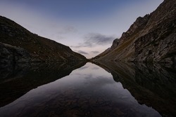 mountains are reflected in the alpine lake and form a symmetrical image