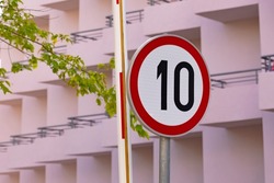 a round sign indicating a speed limit of 10 km on this section of the road. Tools for regulating traffic speed and traffic rules.