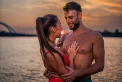 Couple in love having romantic tender moments at sunset on the beach - Young lovers having tender moments in summer vacation - Love concept. Selective focus