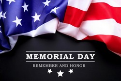 Memorial day weekend text written black chalkboard background with USA flag. United States of America stars & stripes patriot veteran remembrance symbol. Close up, copy space, top view.