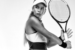 Tennis player. Beautiful girl teenager and athlete with racket in pink sporswear and hat on tennis court. Sport concept.