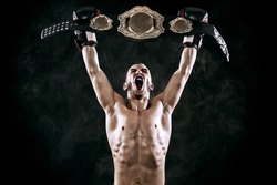 Boxer with Champion belt celebrating flawless victory isolated on black background with copy Space..
