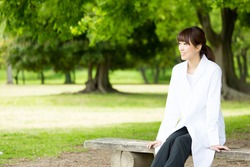 young asian nurse relaxing in the park