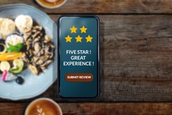 8 Most Trusted Restaurant Review Platforms And Why It Is Important To Monitor Them 2 Customer Experience Concept. Woman using Smartphone in Cafe or Restaurant to Feedback Five Star Rating in Online Satisfaction Survey Application, Food Review, Top View