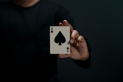 Ace Spade Playing Card. Person Holding a Poker Card. Front View. Closeup and Dark Tone