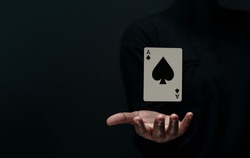 Ace Spade Playing Card. Levitating Poker Card on Hand. Front View. Closeup and Dark Tone