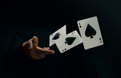 Ace Spade Playing Card. Player or Magician Throwing and Levitating Poker Card by Hand. Front View. Closeup and Dark Tone