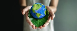 World Earth Day Concept. Green Energy, Renewable and Sustainable Resources. ESG, Environmental, social and corporate governance.Environmental and Ecology Care. Hand Embracing Green Leaf and Globe