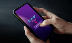Online Donation, Charity and Volunteering Concept. Closeup of Hand Using a Mobile Phone to making Donate via the Internet