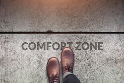 Comfort Zone Concept, Male with Leather Shoes Steps over a word with line on Concrete Floor, Top view