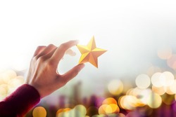 Human Resource Management or Talent Concept, Hand holding and Raise up a Golden Star, Blurred Bokeh Light as background