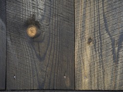 Background from burnt boards. Texture of burnt wood. Black wood wall. Boards after the fire. Pattern. Nails
