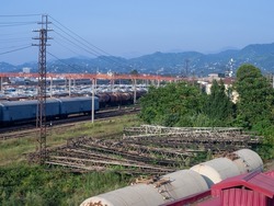 Railroad in the city against the backdrop of mountains. Many railway paths. Wagons and trains on the tracks. unloading station. Tank wagons. Batumi. Old metal structures. industrial zone