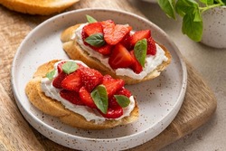 Bruschetta with goat cheese or ricotta witn strawberry and basil. Appetizer with berries. Summer healthy breakfast. Selective focus.