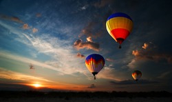 Colorful hot air balloon is flying at sunrise