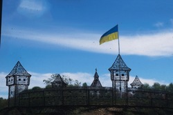 View through time on the castle hill in Vinnitsa with the flag of ukraine against a blue sky with clouds. One of the largest flagpoles in Ukraine