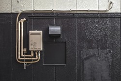 Black and white wall with water heater connected background texture