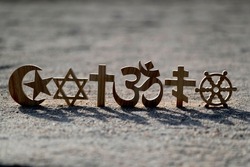 Religious symbols on sand. Christianity, Islam, Judaism, Orthodoxy Buddhism and Hinduism. Interreligious or interfaith concept.
