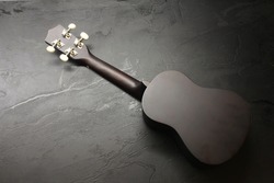 An ukulele on a dark surface