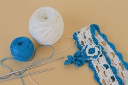 A hair band made of white and blue cotton threads crocheted, threads and a crochet hook, diy.