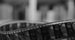 Old cine-film. Film strip on a blur background. Black and white photo.