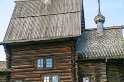 A wooden structure made of huge logs. Cracked dark logs of a wooden house. A large old wooden building built in the 17th century. An old church with wooden domes.