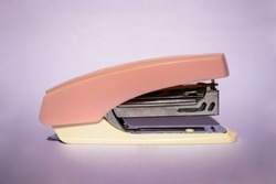 An old light brown stapler which is still in good condition but is starting to rust.