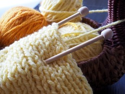 Yellow scarf, knitting, English elastic, balls of yarn.