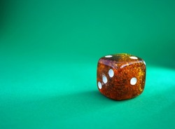 Dice from amber on a green background. The concept of luck, risk, adventure.