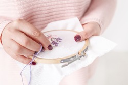 cross-stitched pillow in female hands