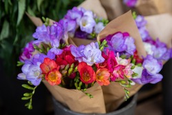 Full buckets of fresh cut beautiful colorful freesia flowers bouquets at the flowers shop in spring time.