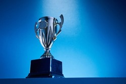 low angle view of winning trophy against blue background