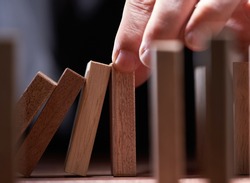 Businessman Stop Domino Effect. Risk Management and Insurance Concept                           
