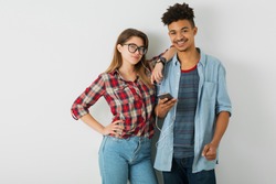 young pretty couple, handsome black man, beautiful girl, glasses, isolated, youth, hipster style, students, friends together, smiling happy, holding smartphone, listening to music on earphones