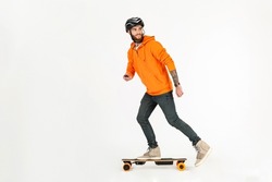 young handsome hipster stylish man skateboarding on electric skateboard isolated on white studio background, dressed in orange hoodie summer street style having fun hoobie