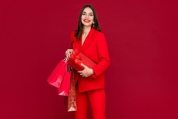 attractive woman in red suit with shopping bags sale on red background happy smiling long hair stylish fashion trend black friday