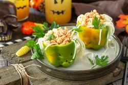 Halloween funny idea for party food, decoration celebration kid party meal. Halloween dinner with Paprika stuffed with spaghetti and chicken tomato bolognese sauce.