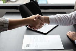 Managers shake hands with applicants after accepting an interview for an accounting position at a company, HR managers are reviewing applicants' resumes, job interview ideas and recruiting.