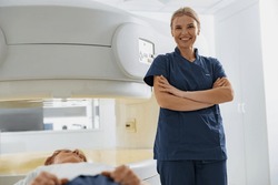 Doctor radiologist on background of MRI or CT Scan with patient. High-Tech medical equipment