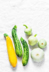 Variety zucchini, squash on a light background, top view. Vegetarian diet food concept. Cooking ingredients
