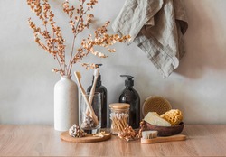 Bathroom interior still life. Decorative flowers, shampoo bottles, cotton buds, brushes, soap, towels on a wooden background. Minimalism interior      