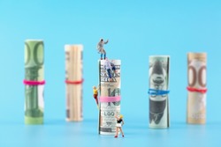 Miniature creative banknotes climbing in pursuit of money