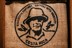 A brown coarse jute sack with a large stamp imprinted with coffee from Costa Rica
